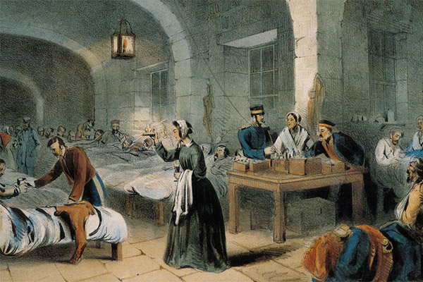 Victorian painting showing Florence Nightingale checking on the wounded in a hospital at night. She holds her iconic lamp.