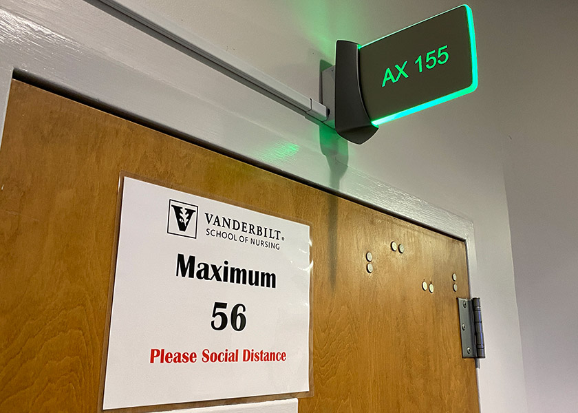 Photo of classroom with sign saying maximum occupancy is 56 people