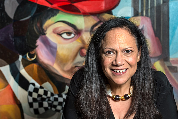 Author Alice Randall in front of a colorful mural of Black men