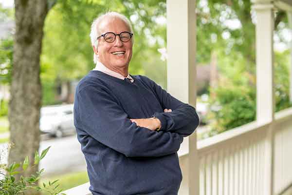 Vanderbilt professor Tom Christenbery leans against porch rail in portrait for Summer 2020 Vanderbilt Nurse magazine.