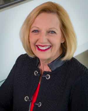 Debbie Arnow, dressed in business attire, smiles at camera