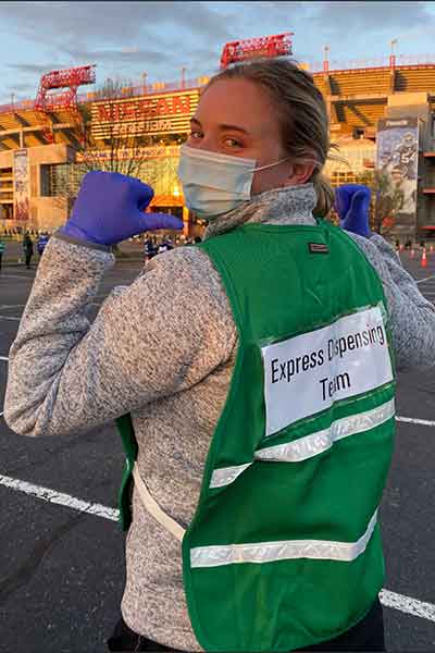 Hannah Hunt in green safety vest that reads Express Dispensary Team