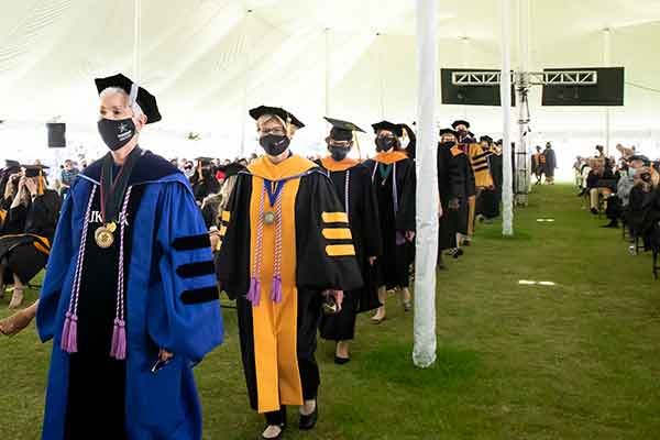 Dressed in academic regalia, faculty emeriti Susie Adams and Melanie Lutenbacher process into Commencement 2021