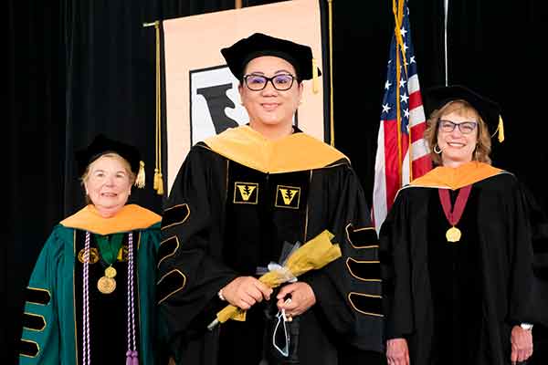 Dean Norman, Monaliza Gaw, Terri Allison stand on stage 