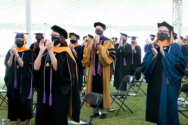 Faculty, graduates and guests give Dean Linda Norman a standing ovation