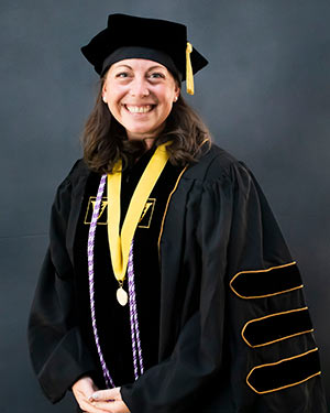 Rebecca Silvers portrait wearing fill academic regalia with VUSN Founder's Medal around her neck