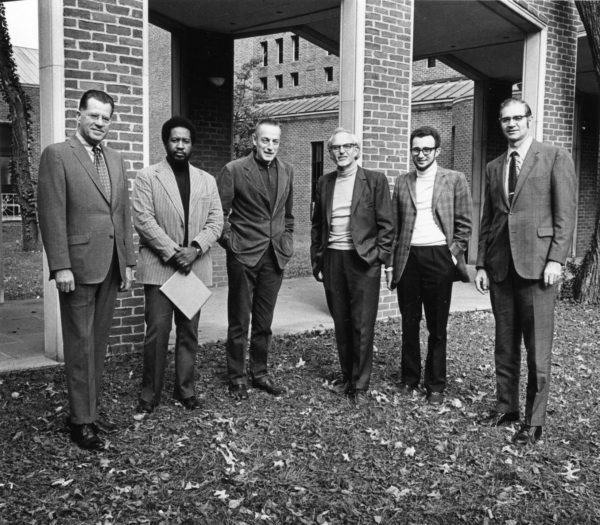 Religious Studies faculty in 1973; six men standing in front of campus building