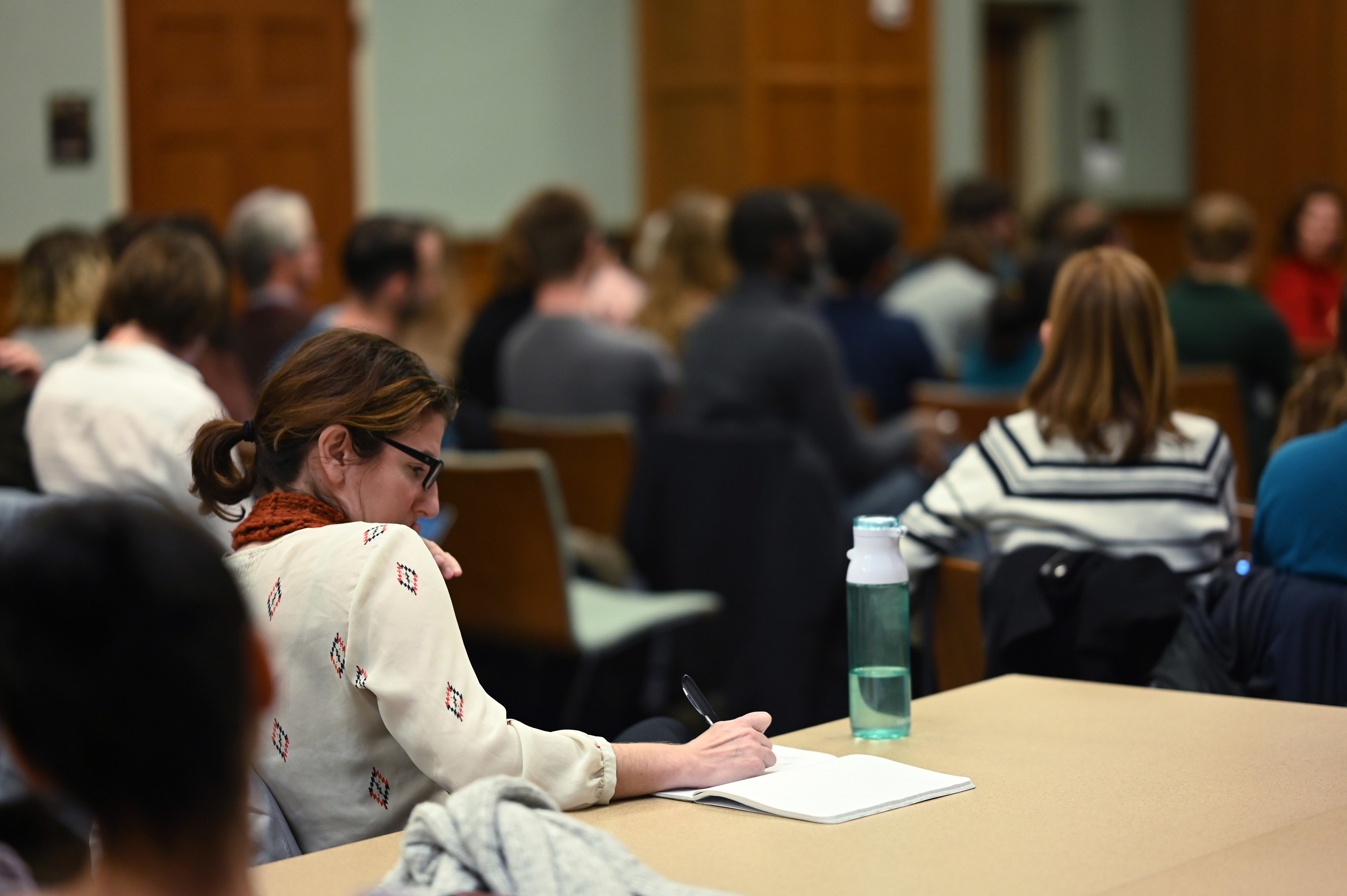 person taking notes at panel session