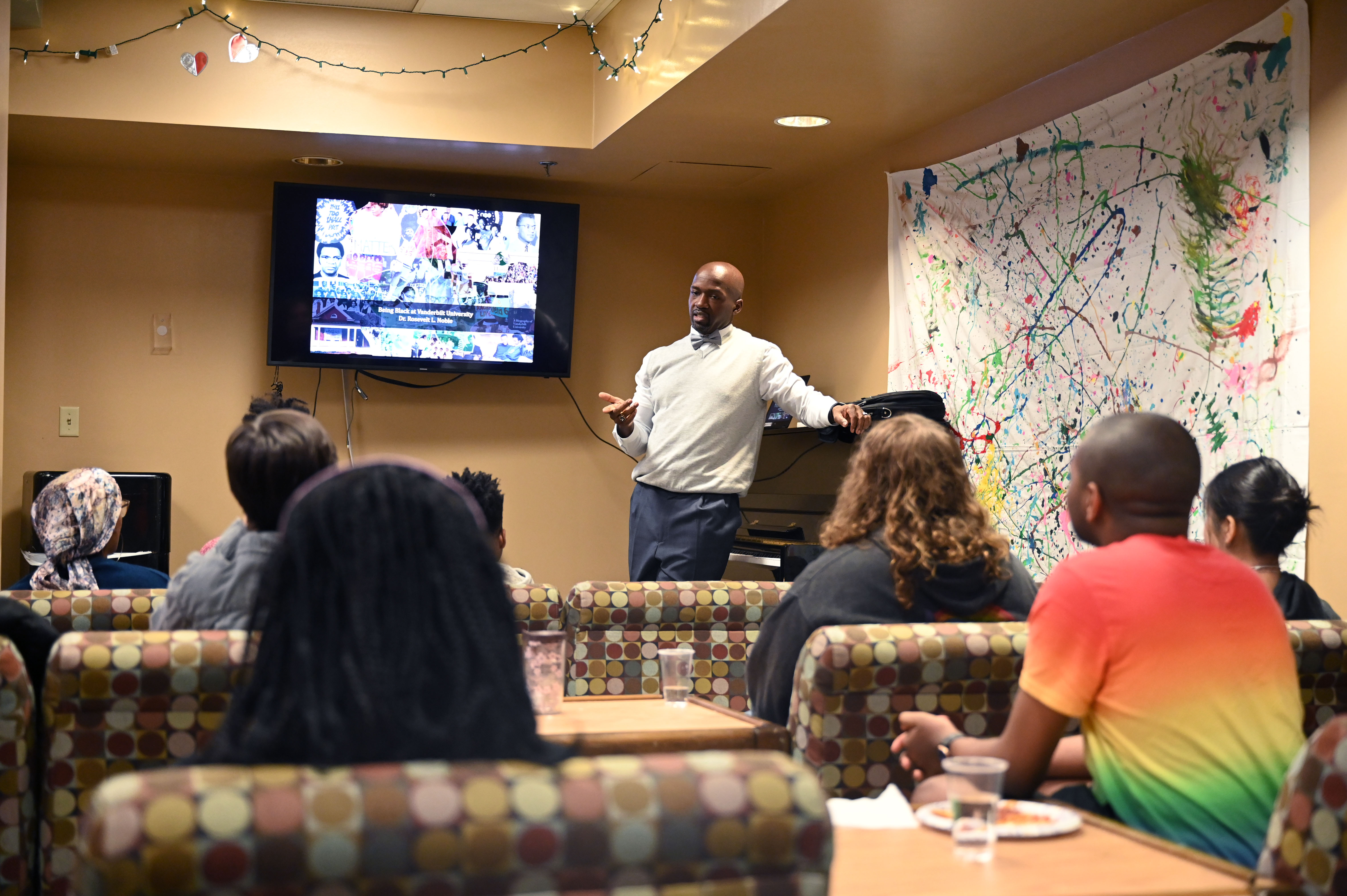 Rosevelt Noble giving a presentation to students in a commons room