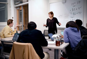 Woman teaching in front of class.