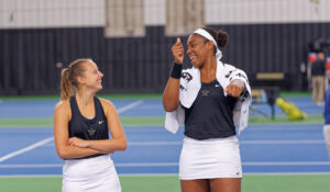 two tennis players laughing