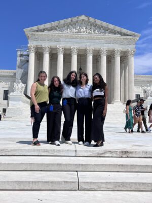 Five woman posing on steps