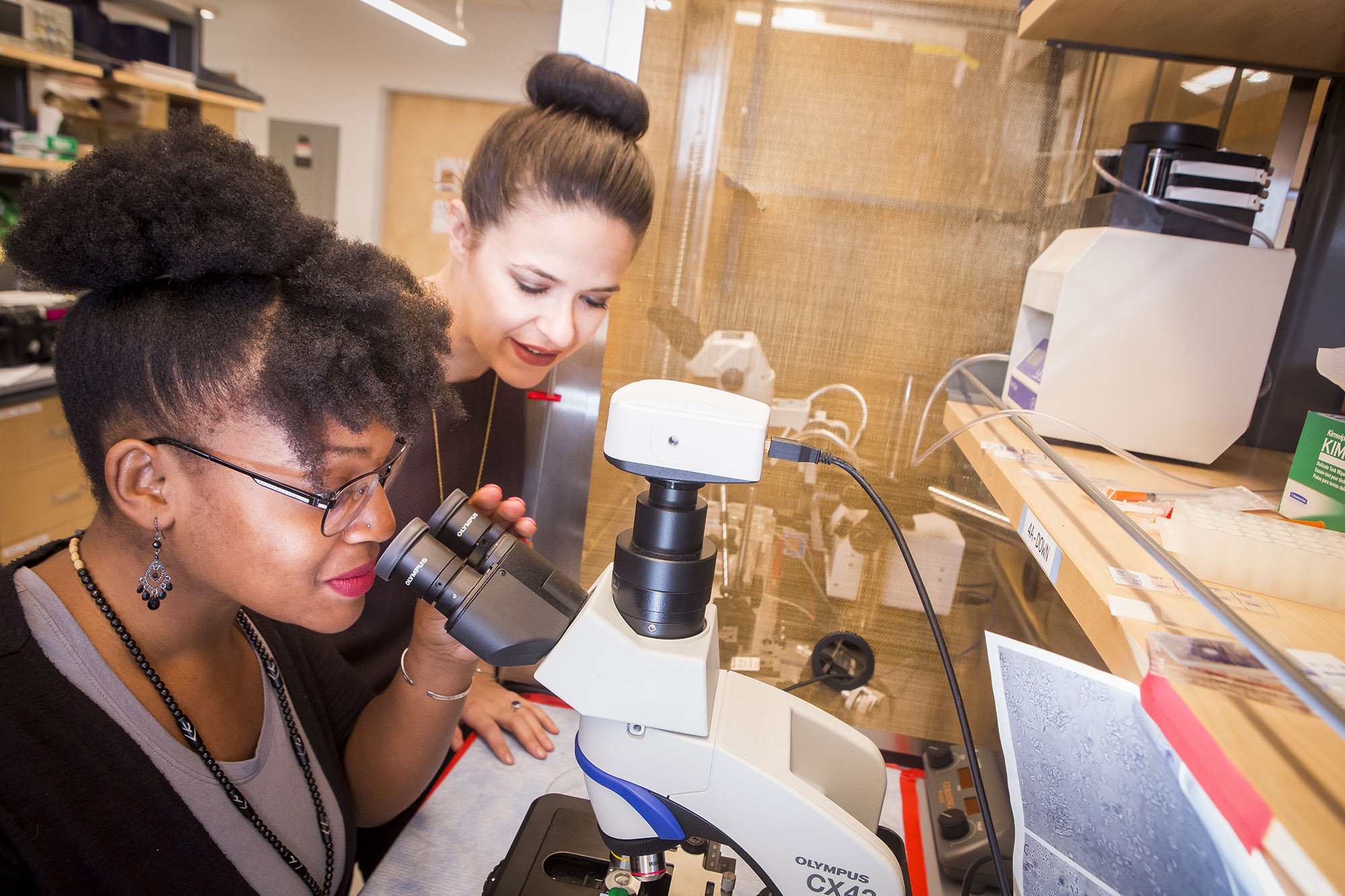 student looking in microscope