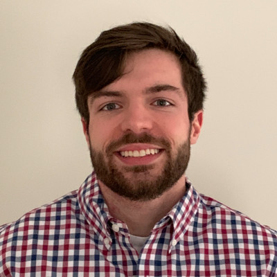 Man with brown hair and beard and checkered button-down